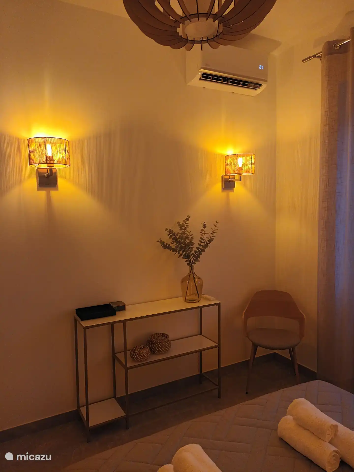 Zona de estar y dormitorio beige con iluminación ambiental