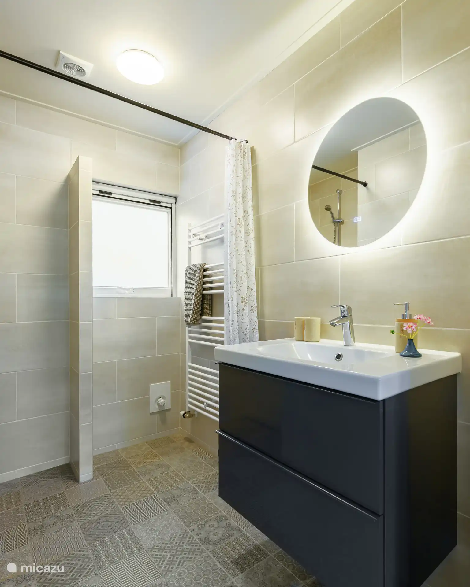 De badkamer met inloopdouche en wastafelmeubel