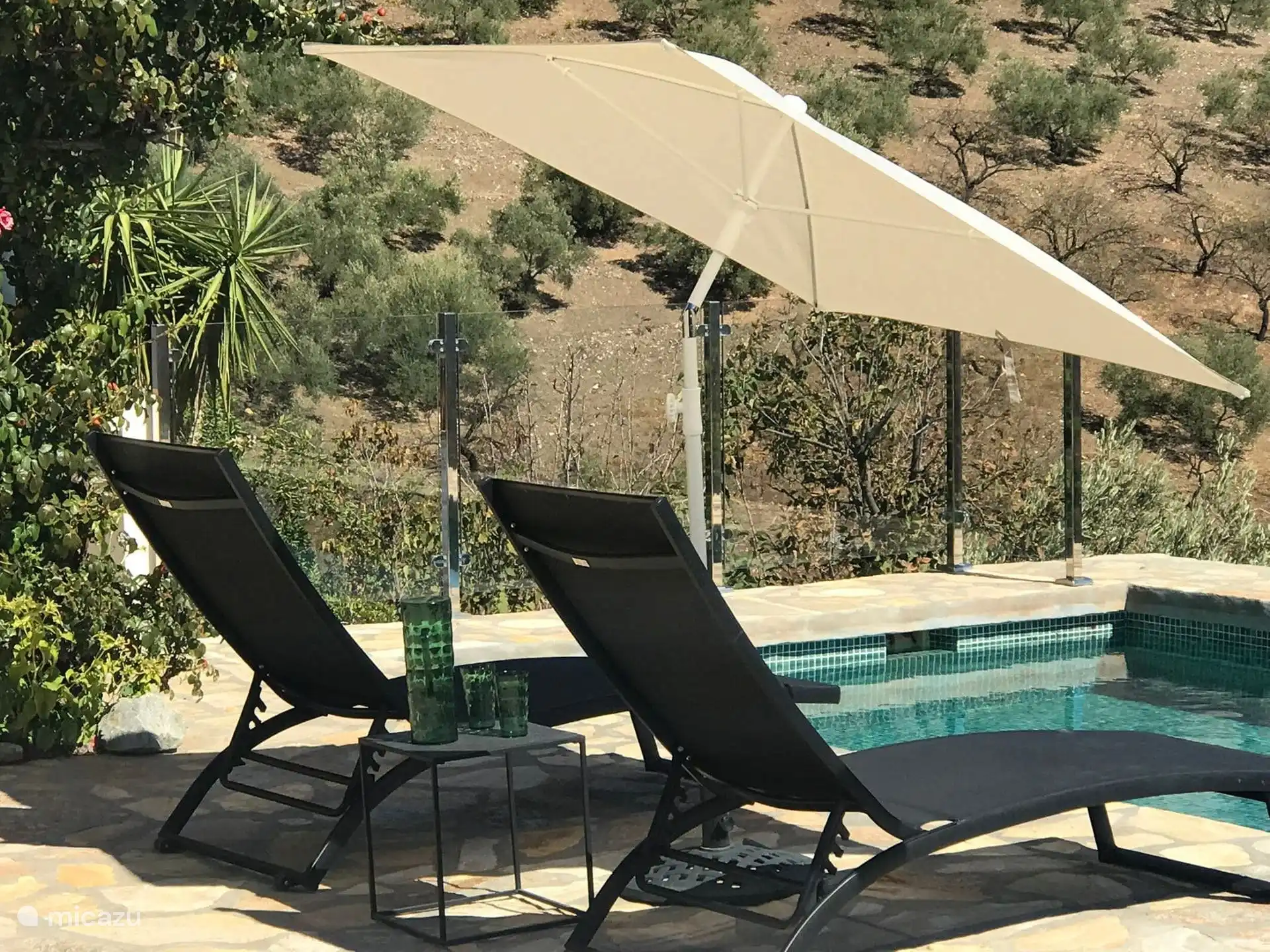 Tumbonas junto a la piscina con una gran vista