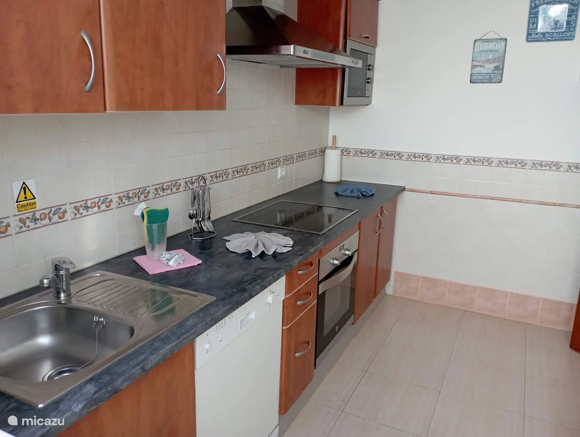 The kitchen with a hob, oven, dishwasher and plenty of kitchen utensils