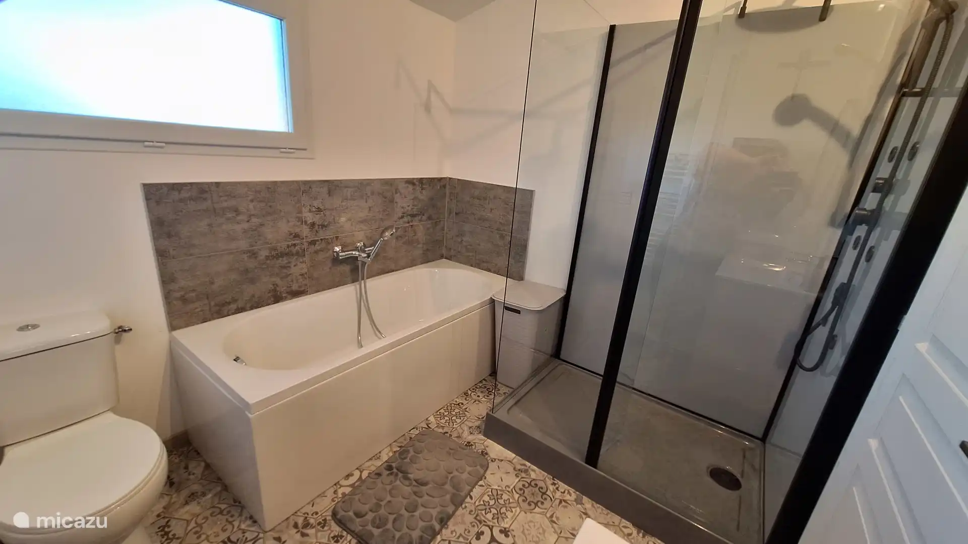 Badezimmer mit Unterschrank, Dusche, Badewanne und WC