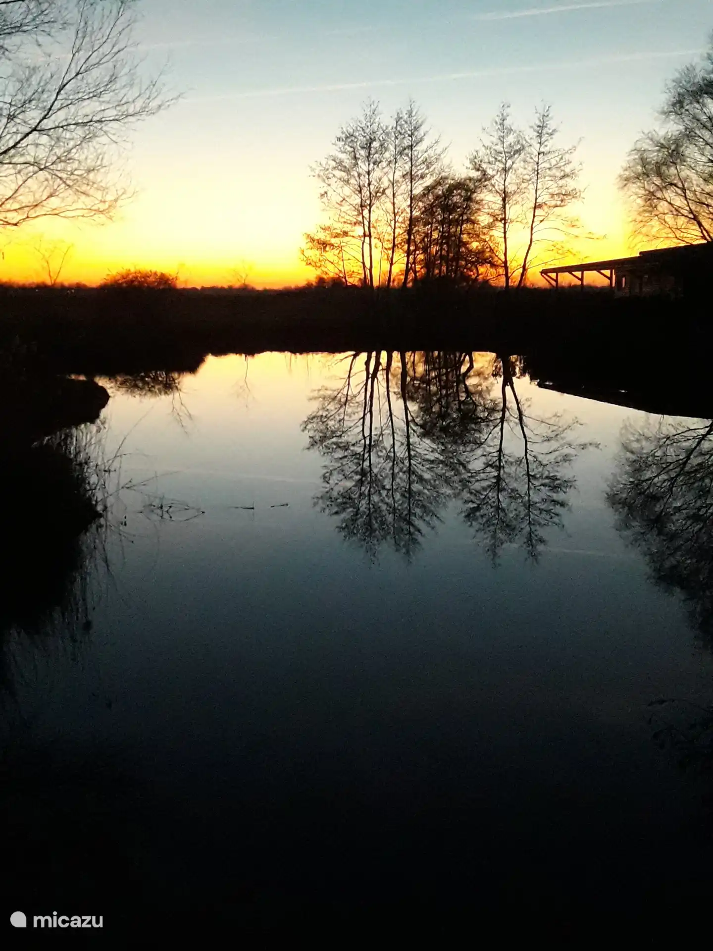 L’étang au coucher du soleil, à droite on peut voir la véranda / la canopée de la maison mobile.