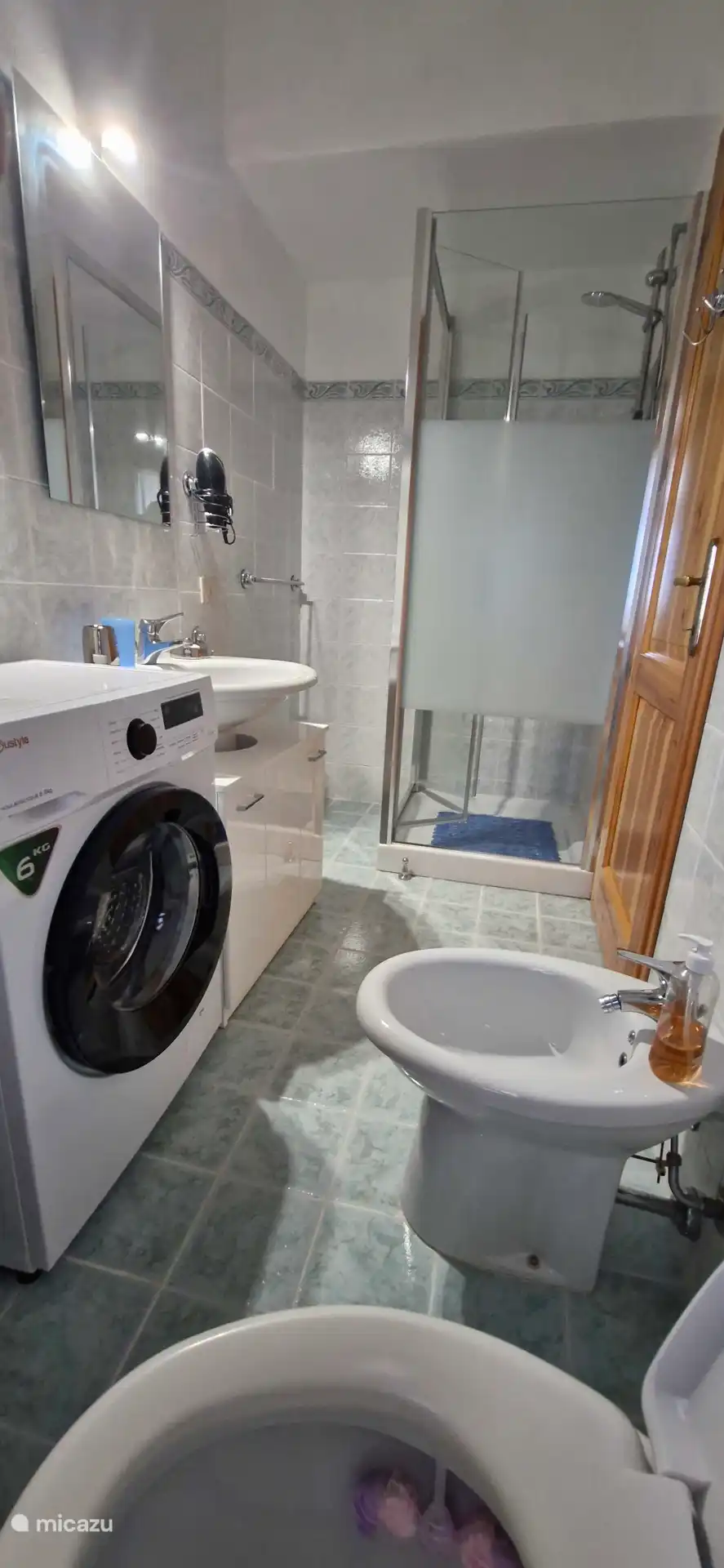 Baño con ducha, inodoro, bidé y lavadora