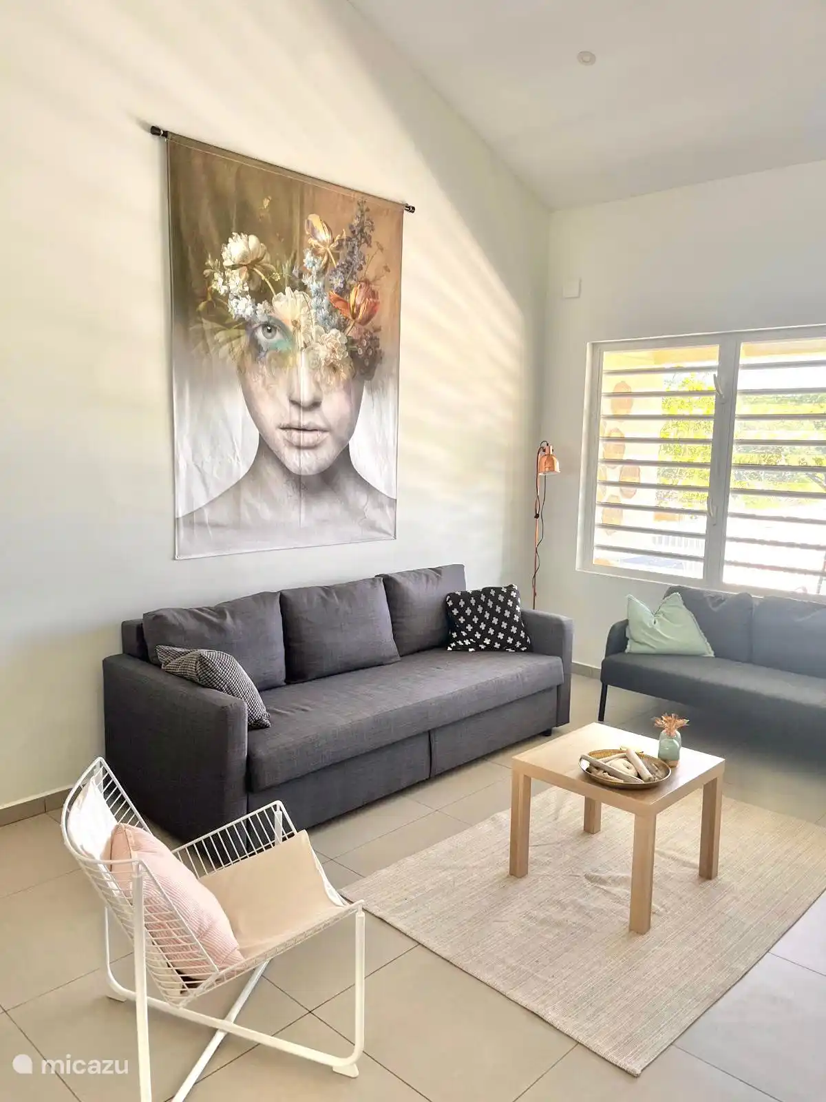 Zithoek met decoratie en openslaande shutters om de verfrissende wind binnen te laten.