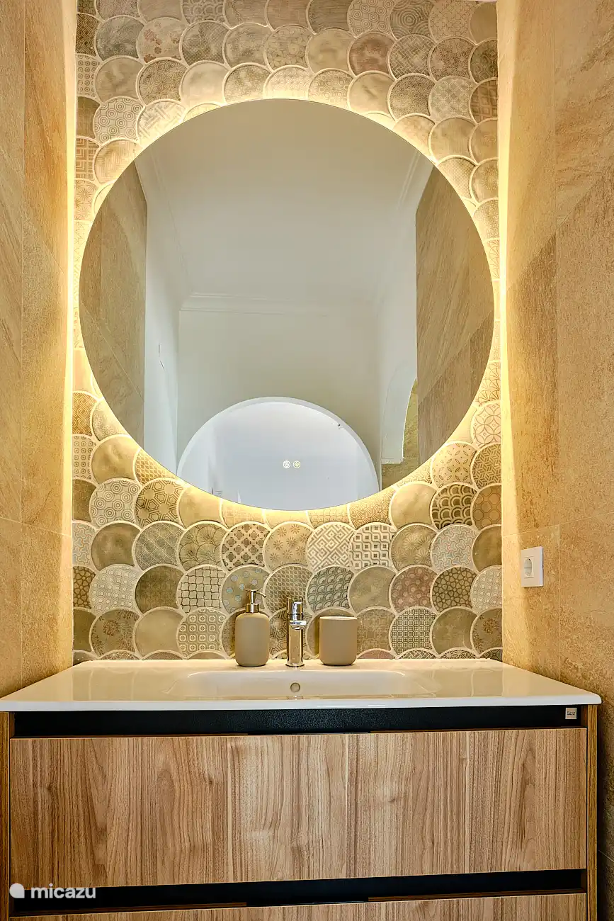 Ensuite Badezimmer mit Waschbecken, ebenerdiger Dusche und WC.