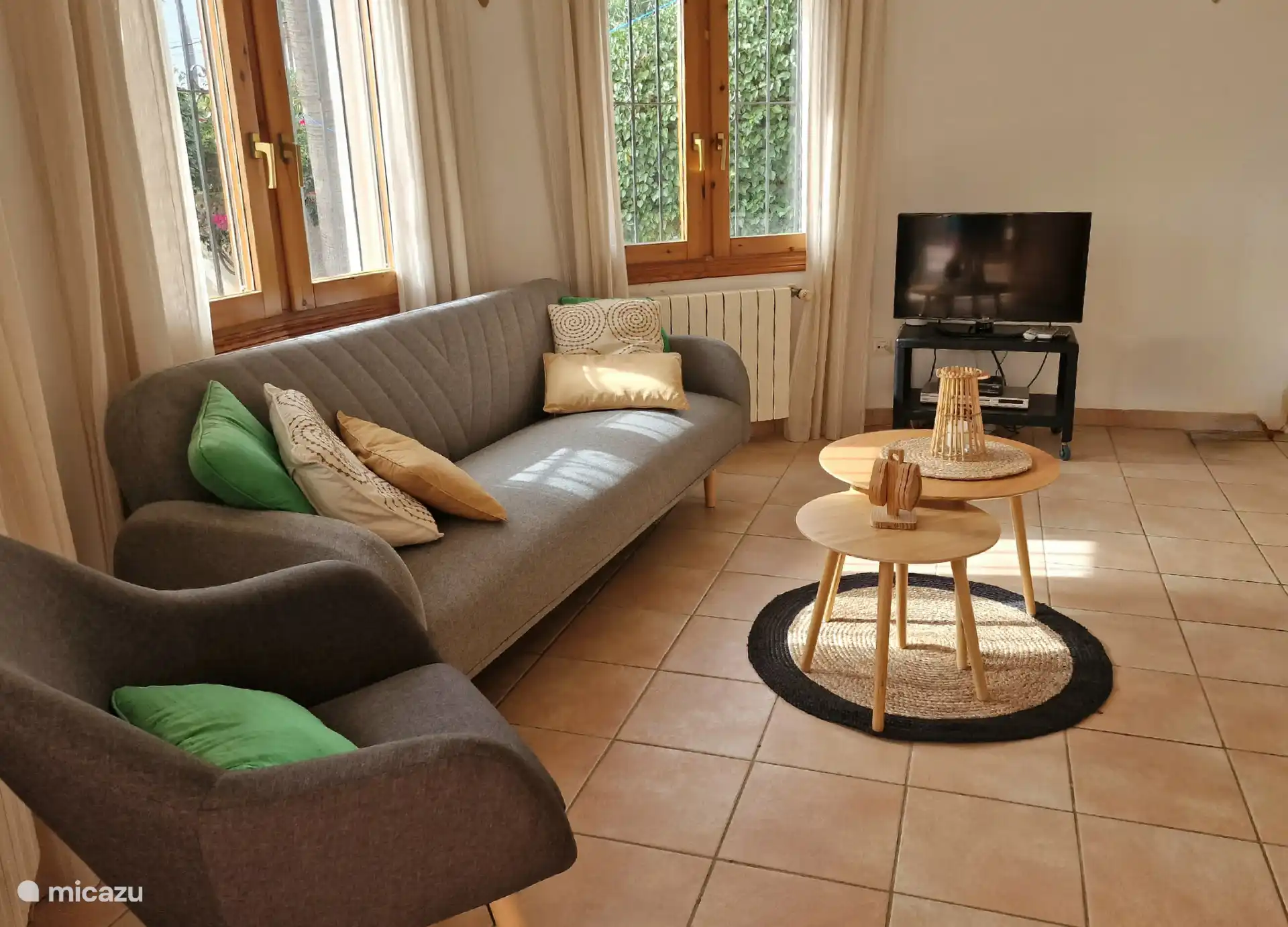 Du salon avec coin salon, TV LED et coin repas, vous avez accès à la terrasse couverte spacieuse et charmante avec des sièges et une vue sur les magnifiques environs. 