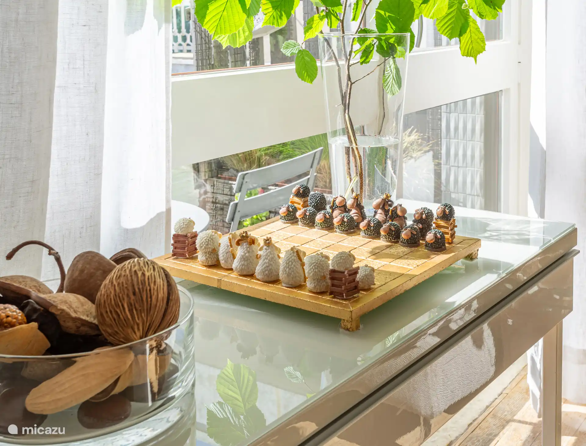 Handgemaakt schaakbord op de tafeltafel in de woonkamer, geplaatst tussen de balkon- en terrasdeuren, wat charme en een verfijnde persoonlijke touch toevoegt.