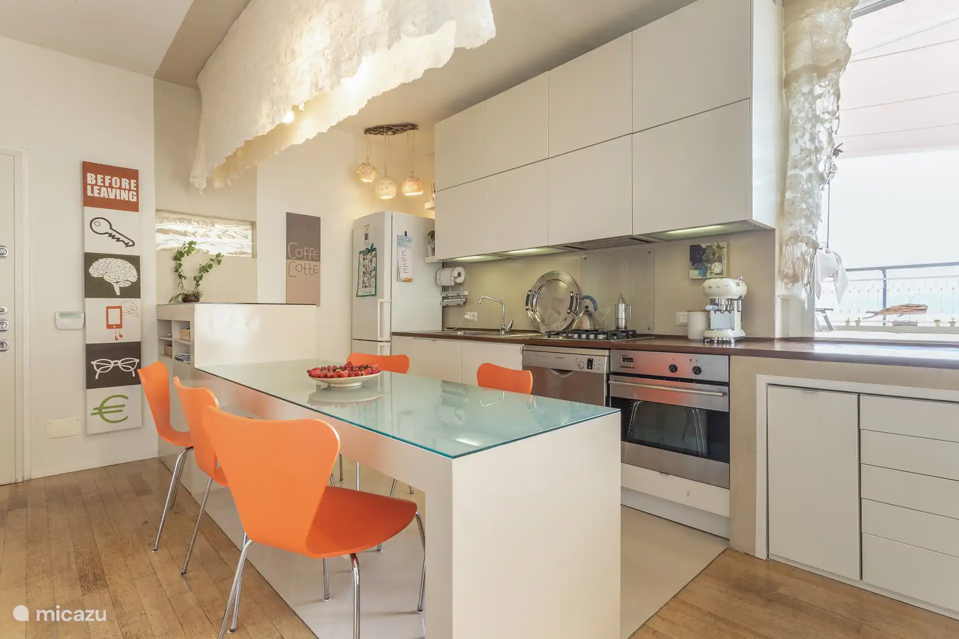 Cocina luminosa y bien equipada con cafetera espresso Smeg, aire acondicionado y acceso a la terraza a través de cuatro escalones.