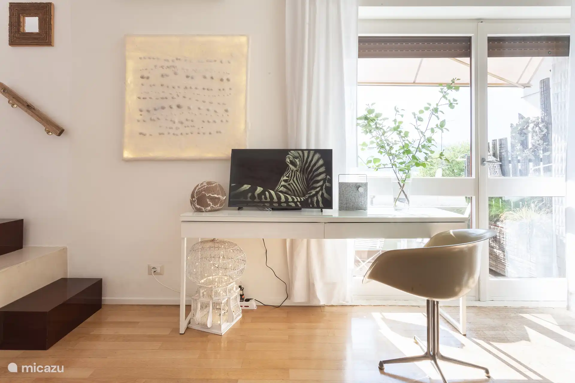 Rincón de trabajo con Smart TV en la sala de estar con aire acondicionado, ubicada cerca de la salida del balcón.