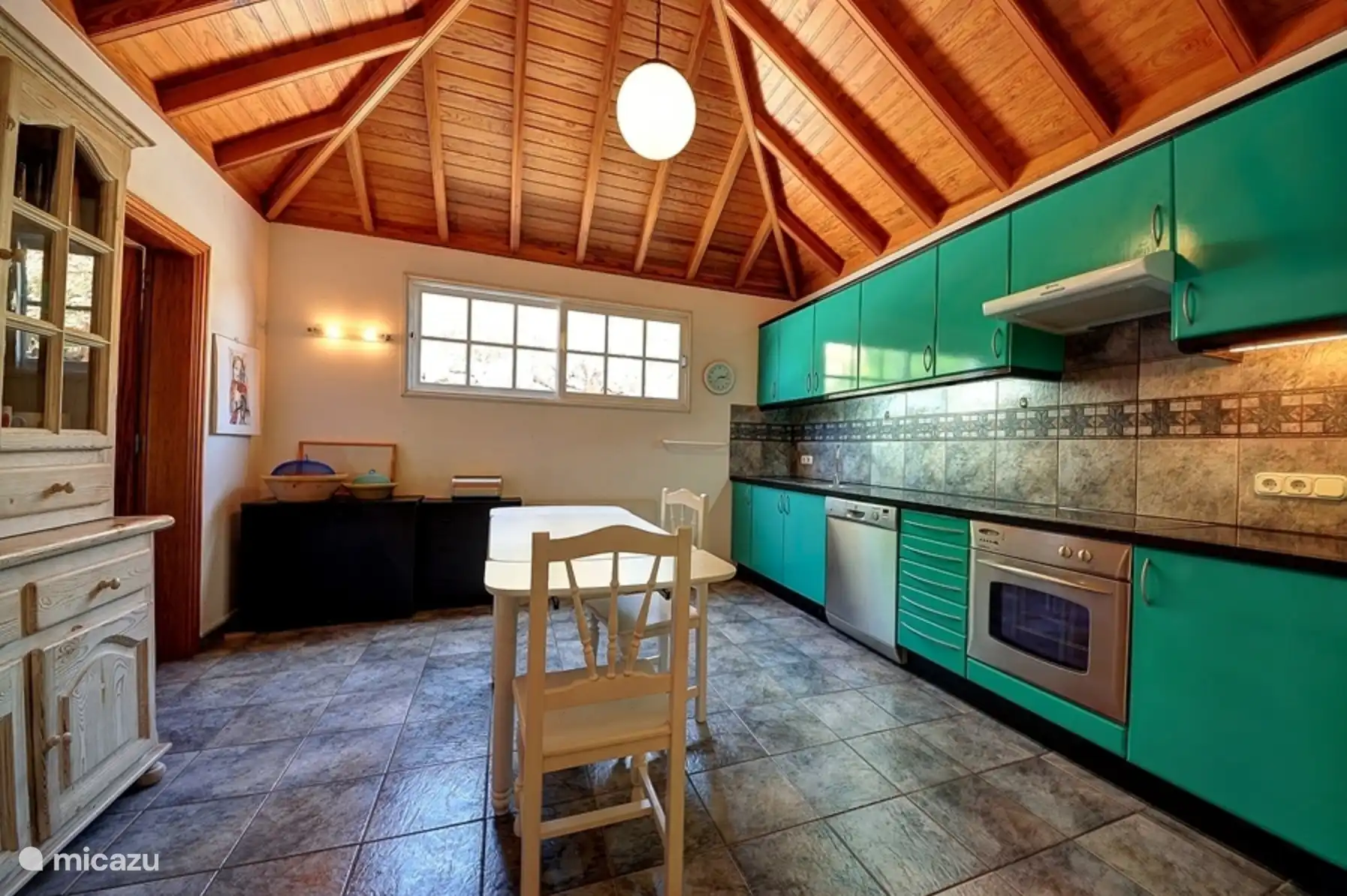 Die Küche ist mit einem weiteren Esstisch ausgestattet.