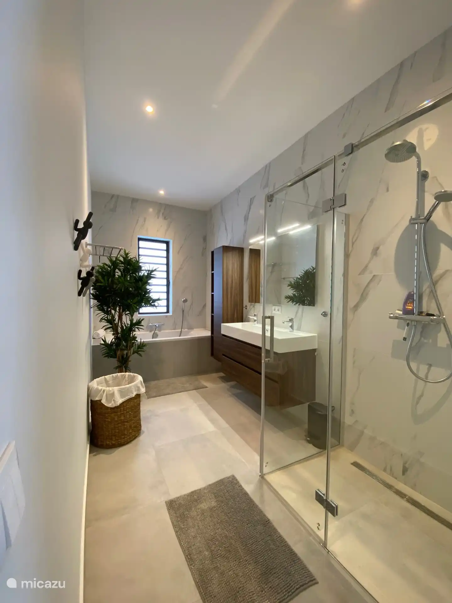 Salle de bain avec baignoire et cabine de douche séparée. Cette chambre dispose également de la climatisation