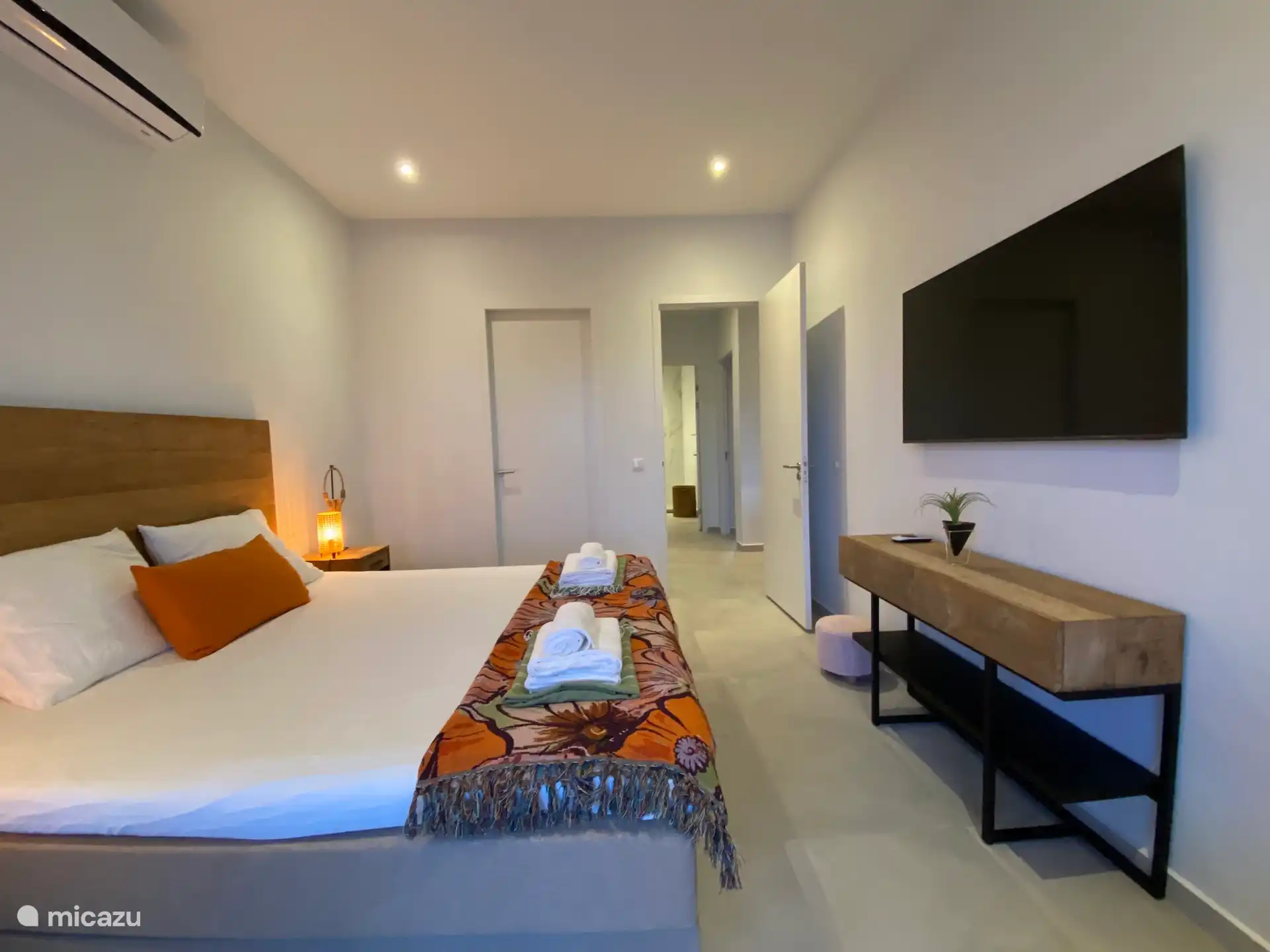 Chambre principale, avec télévision intelligente, salle de bain privée et accès à la terrasse.