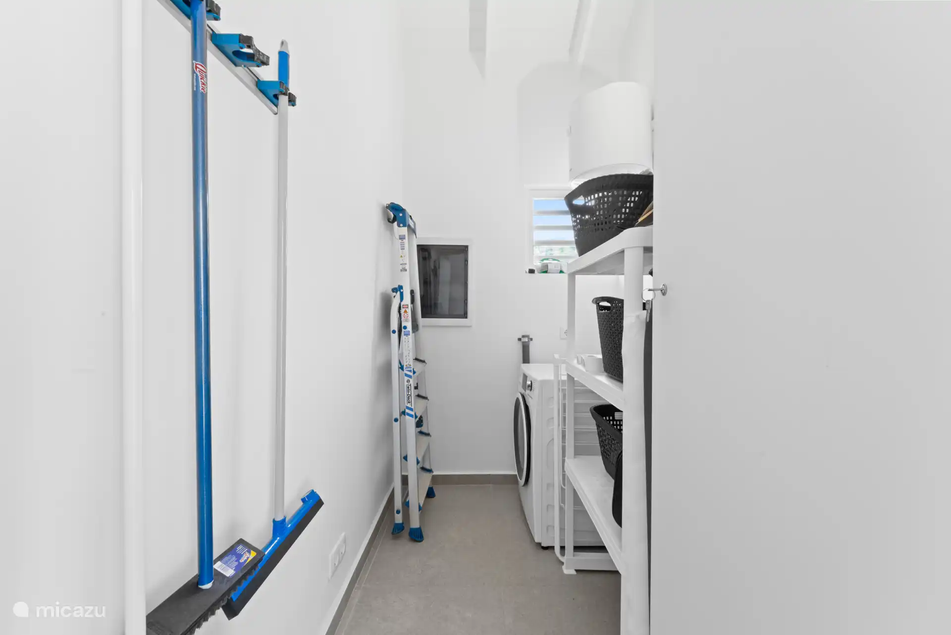 The storage room with the washing machine, ironing board etc 