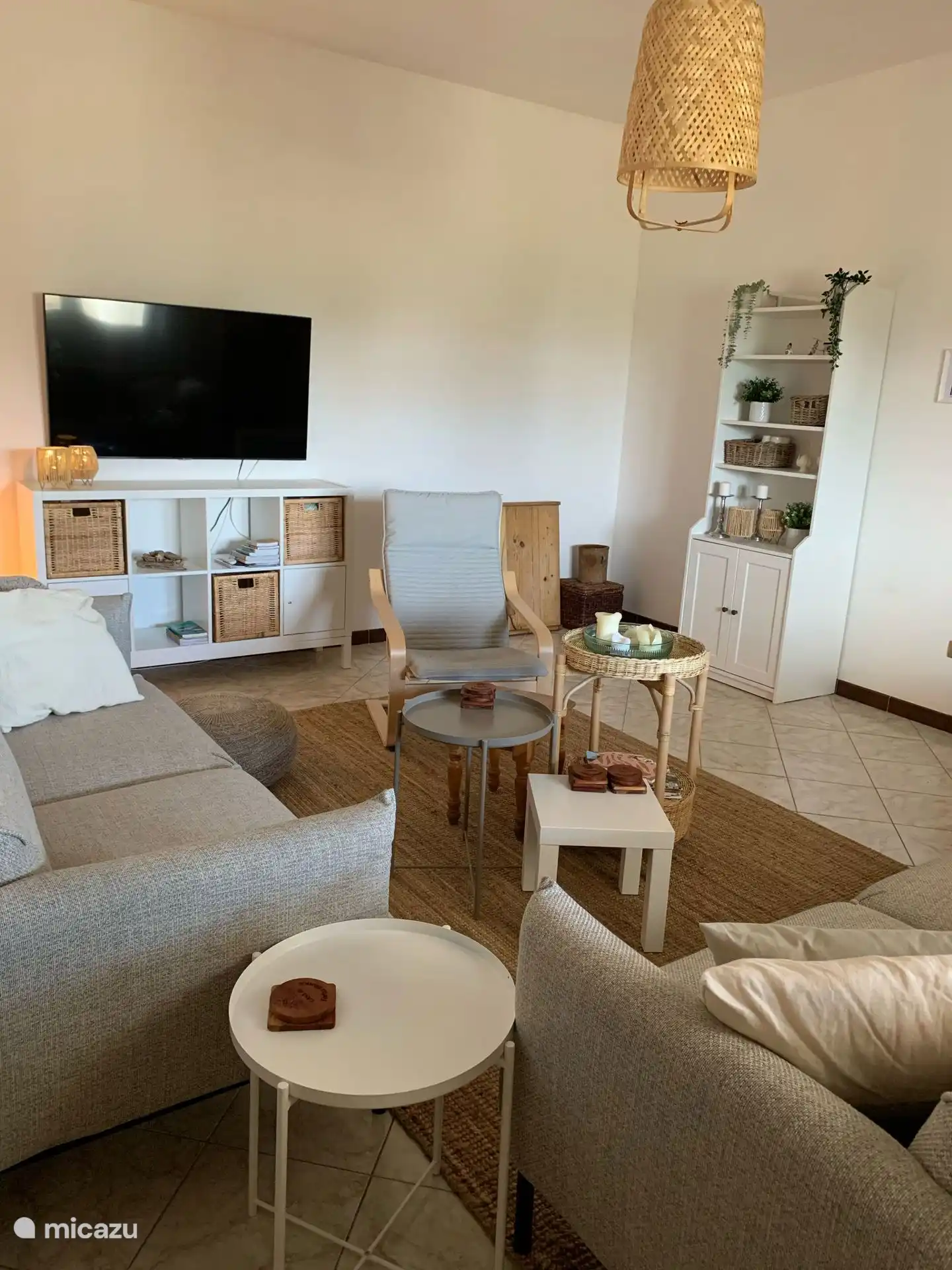 Ein gemütliches Wohnzimmer mit vielen Sitzmöglichkeiten und einem großen Flachbildschirm