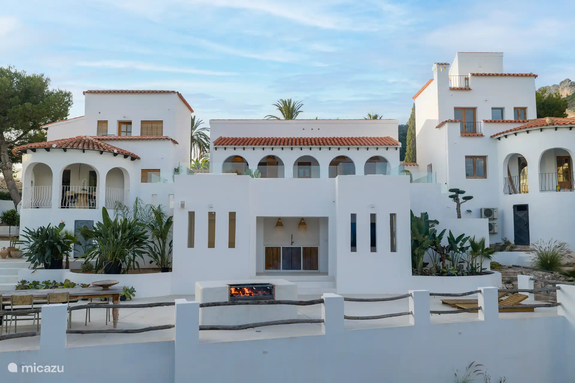 Arrière complet de la maison. 
Vue dégagée sur la terrasse et la cuisine extérieure.