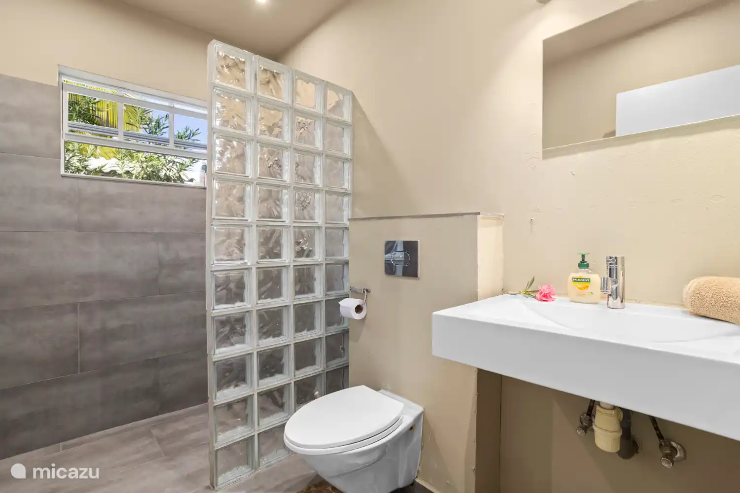 Badkamer met douche, wastafel en toilet.