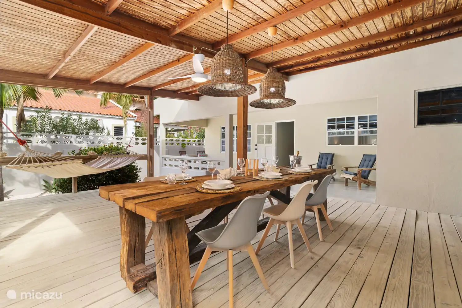 Veranda met sfeervolle eettafel en hangmat