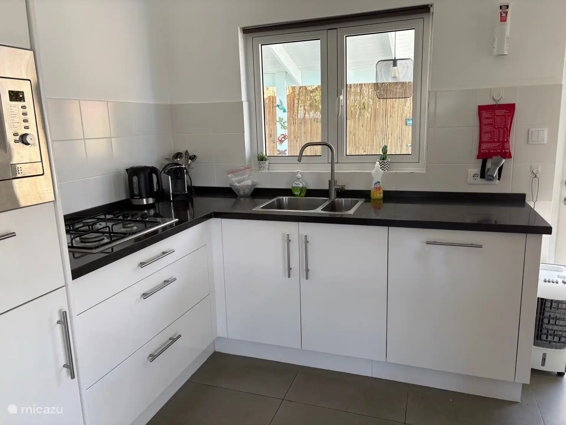 De volledig uitgeruste keuken heeft ook een ...