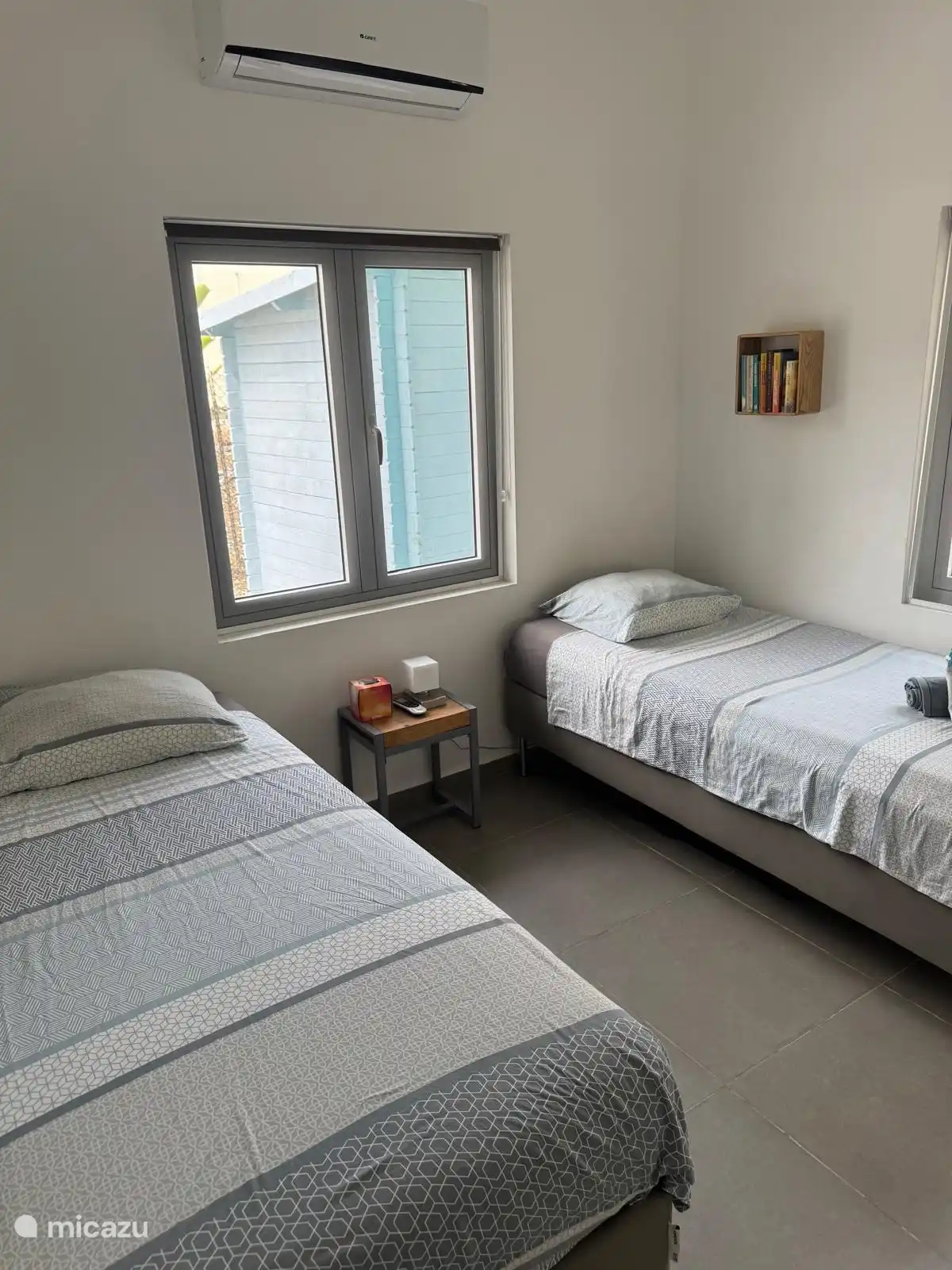 Een andere slaapkamer heeft twee eenpersoonsbedden en airconditioning.