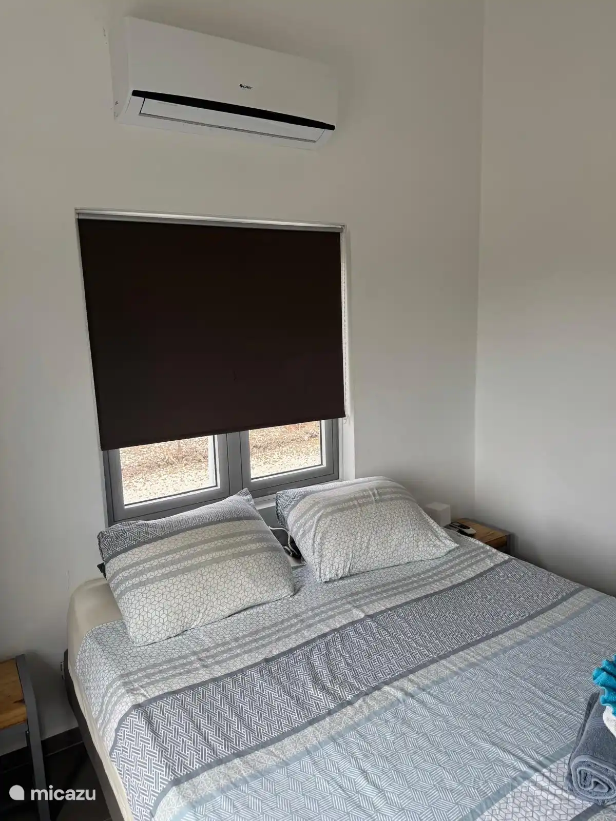 Een slaapkamer met een tweepersoonsbed en airconditioning.