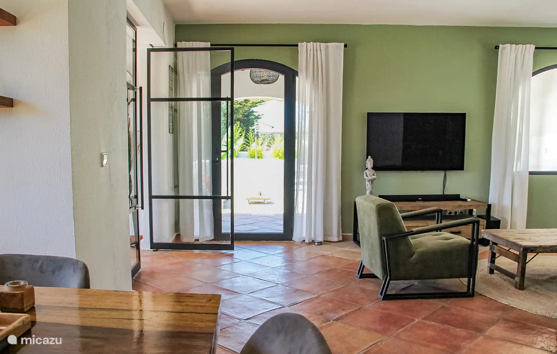 Das Wohnzimmer verfügt über einen Smart-TV, eine Musikanlage und eine Sitzecke.