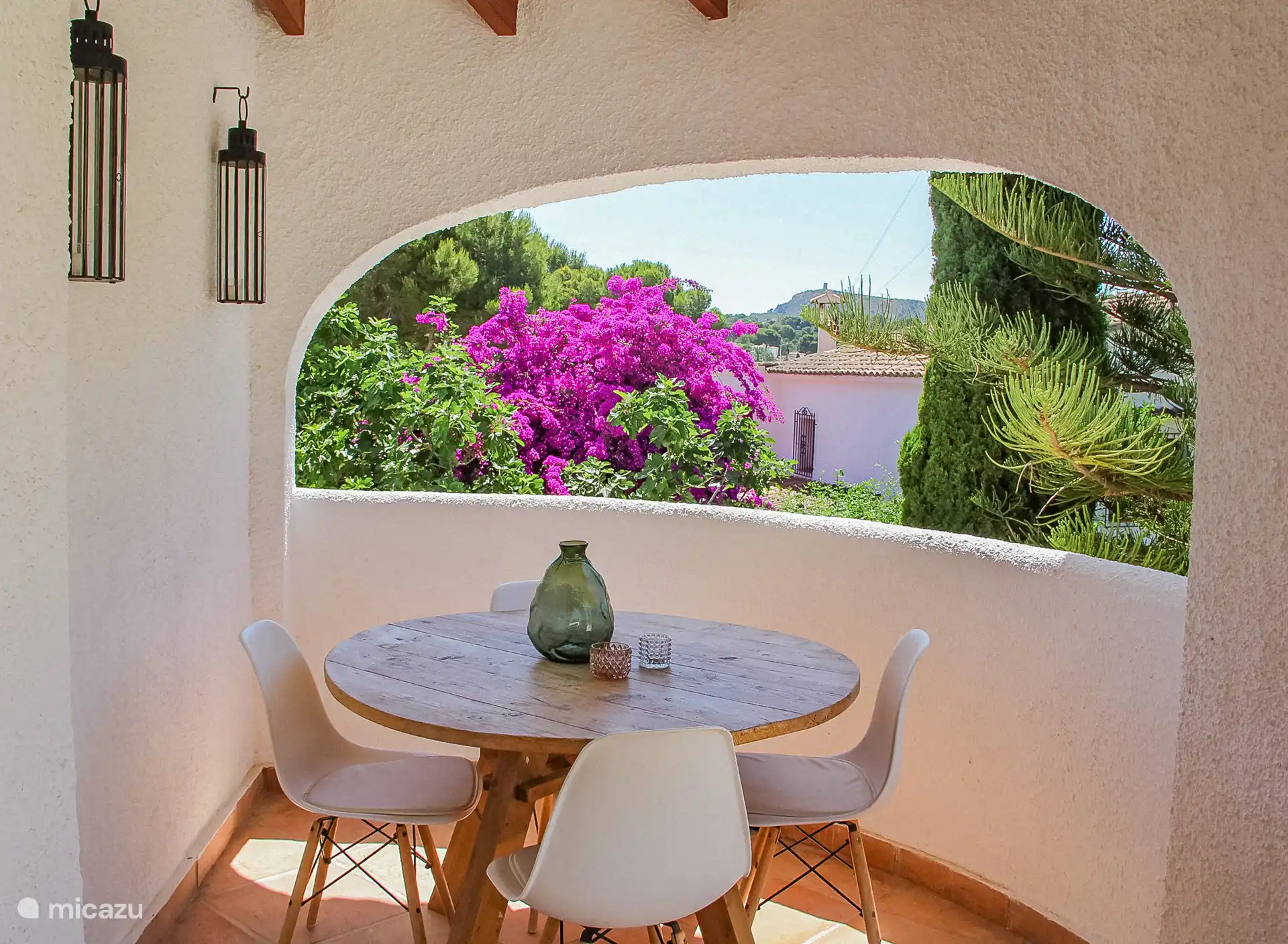 Vom Wohnzimmer aus gelangt man auf die Veranda, hier befindet sich ein Lounge-Sofa und ein kleiner runder Esstisch.