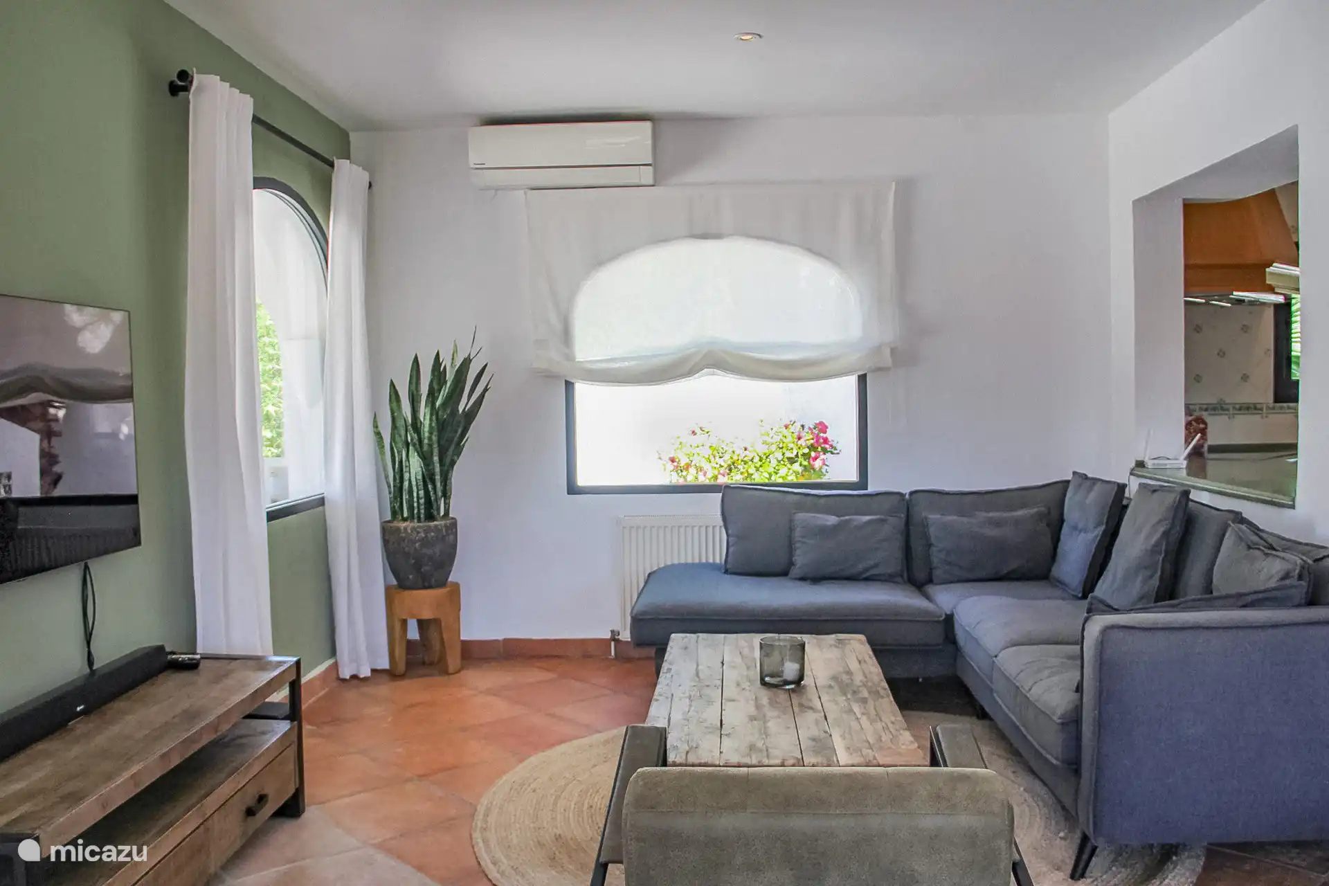 Das Wohnzimmer verfügt über einen Smart-TV, eine Musikanlage und eine Sitzecke.