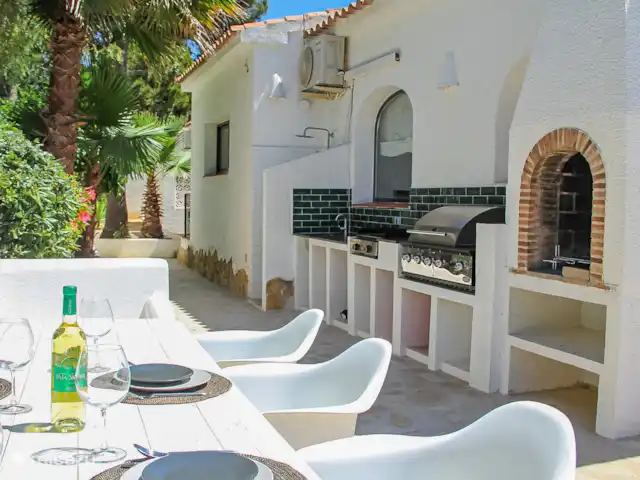 Casa Contenta en España, Costa Blanca, Moraira - villa La mesa de comedor se encuentra cerca de la cocina exterior con gran barbacoa de gas.