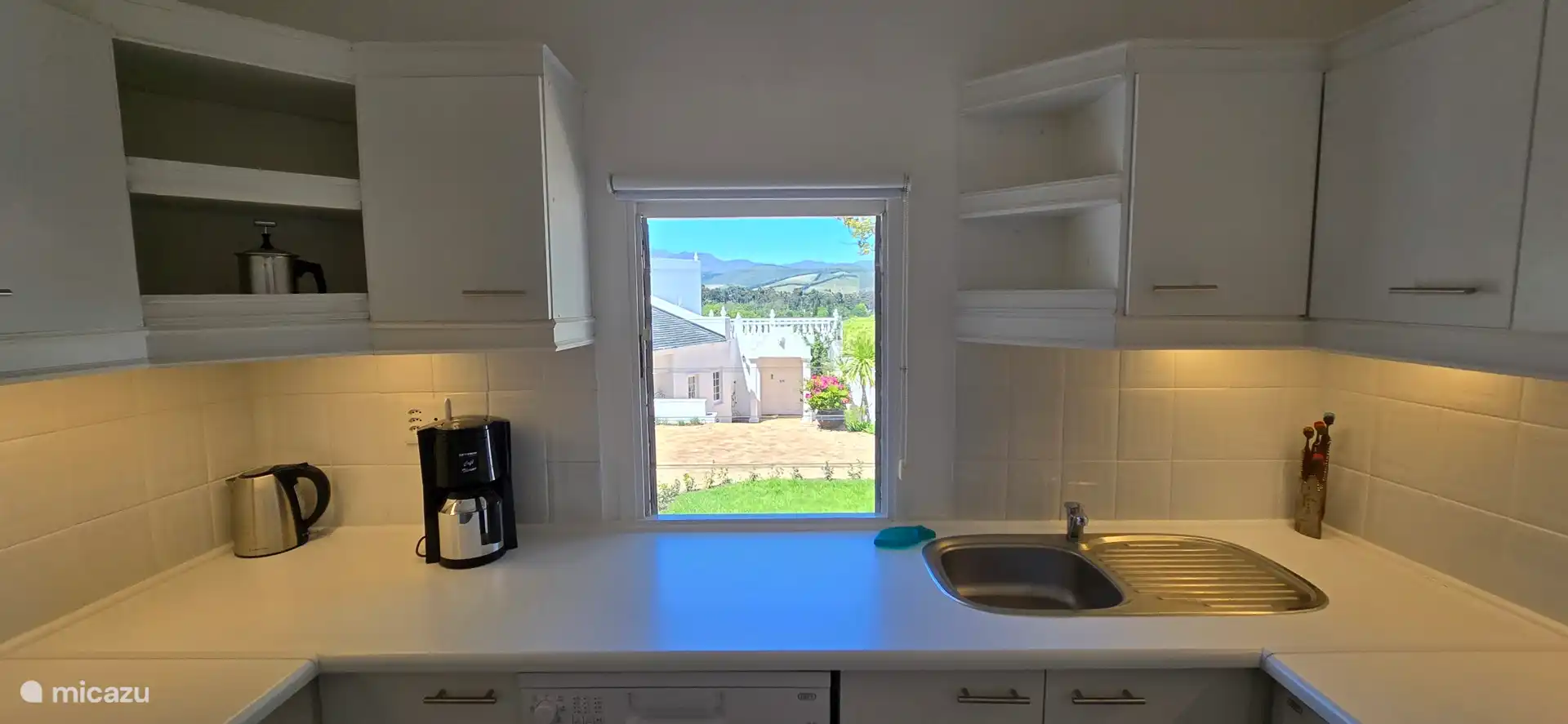 Voll ausgestattete weiße Küche mit schönem Blick nach draußen