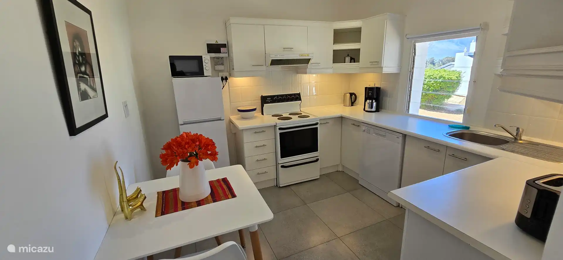 Voll ausgestattete Küche mit Mikrowelle, Kühlschrank mit Gefrierfach, Waschmaschine, Geschirrspüler und einem 4-Flammen-Herd und Backofen