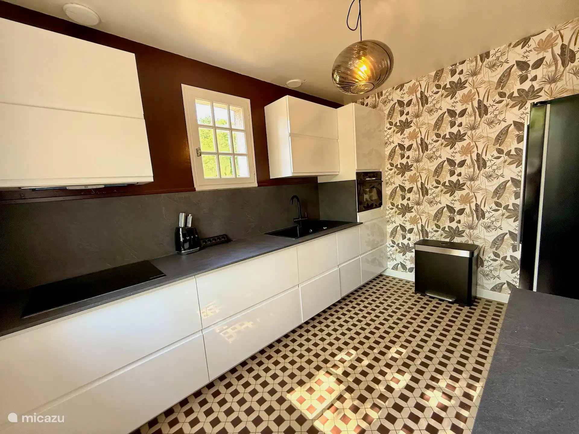 Complete keuken met kokend waterkraan en grote Amerikaanse koelkast.