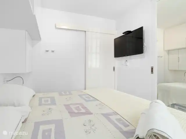Port Bonaire - Piscina, mar y tienda de buceo en Bonaire, Bonaire, Kralendijk - apartamento Dormitorio con aire acondicionado y TV