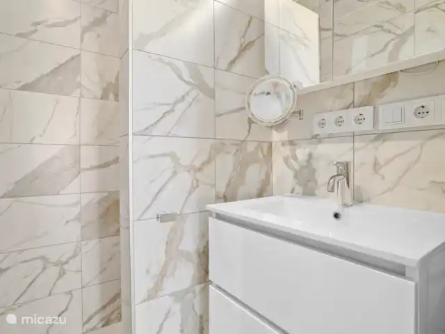 Port Bonaire - Piscina, mar y tienda de buceo en Bonaire, Bonaire, Kralendijk - apartamento Baño moderno con ducha a ras de suelo, inodoro cerrado separado y 220 enchufes