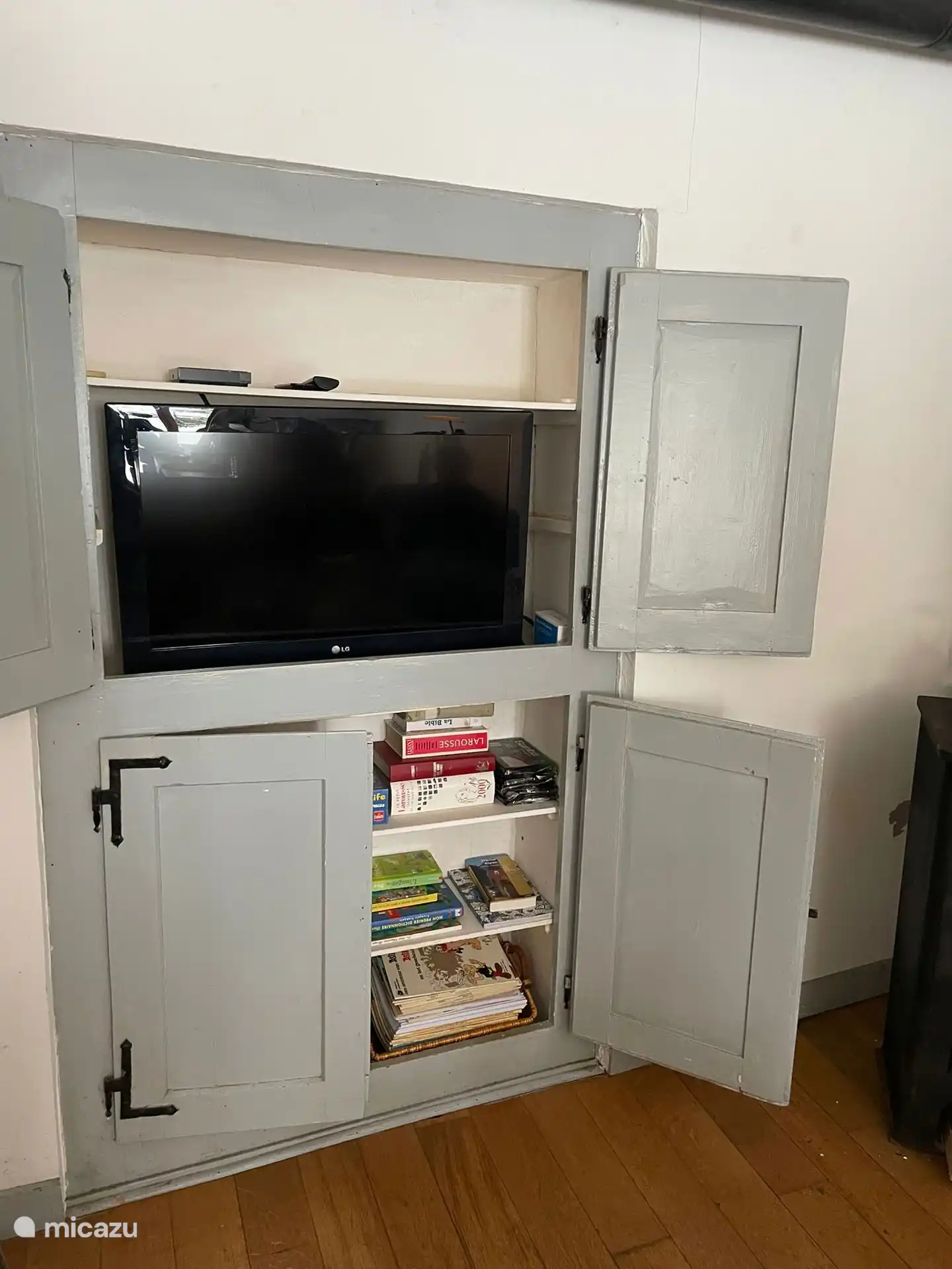 Ingebouwde kast met tv, spelletjes en  leesboeken.