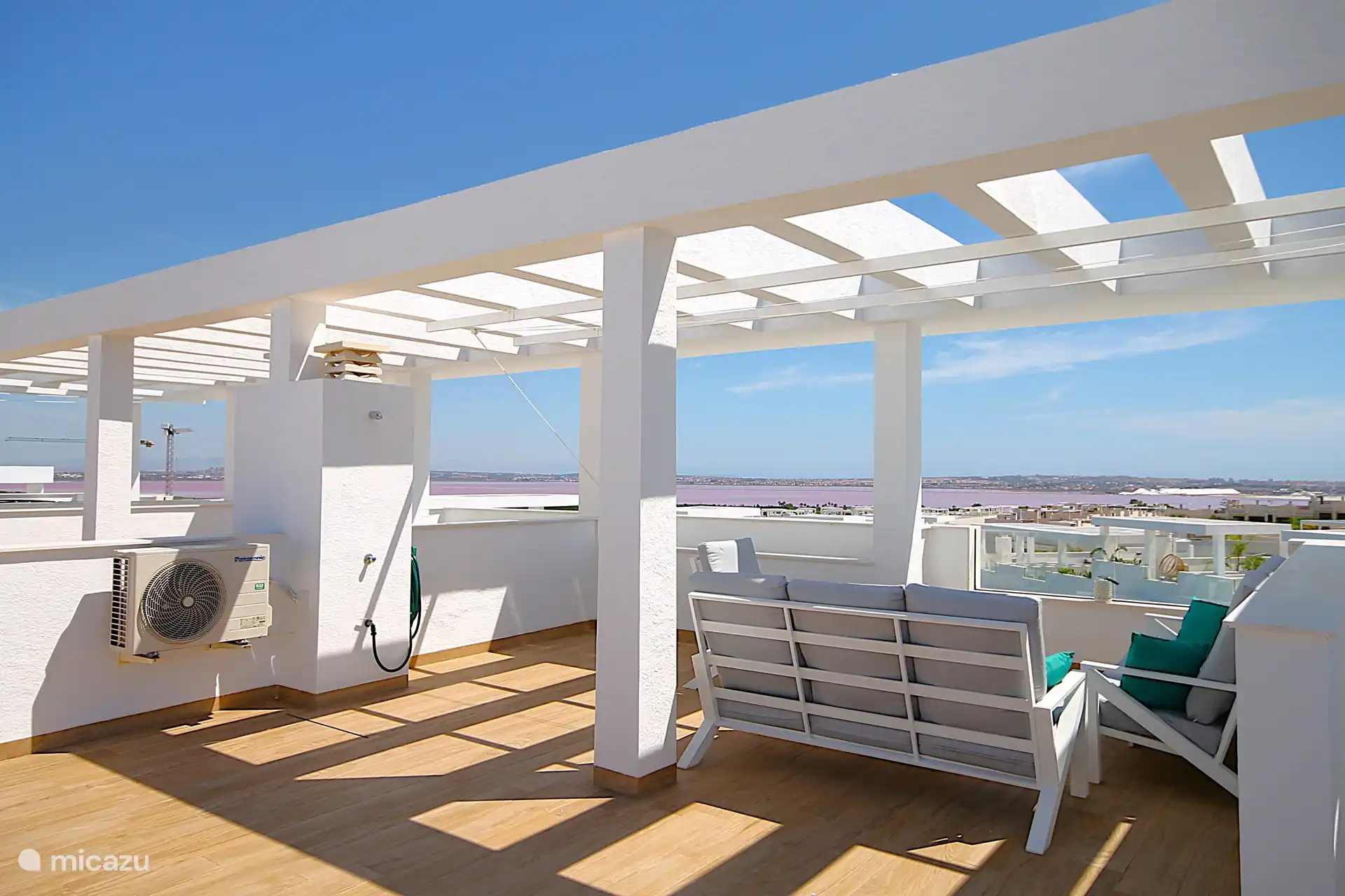 Solarium mit Außendusche, Grill, Außenküche und Blick auf den Salzsee, das Meer, den Pool und den Garten.