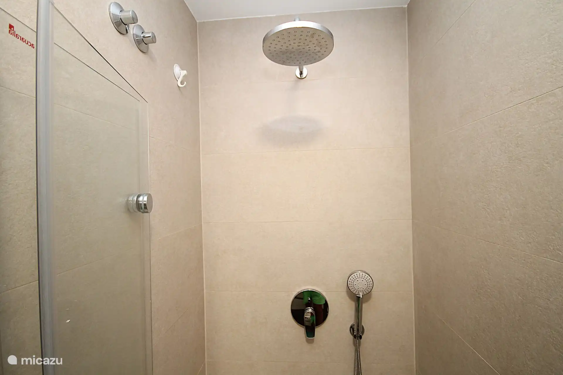 Badezimmer 1 mit Dusche, Waschbecken, Fußbodenheizung und hängendem WC.