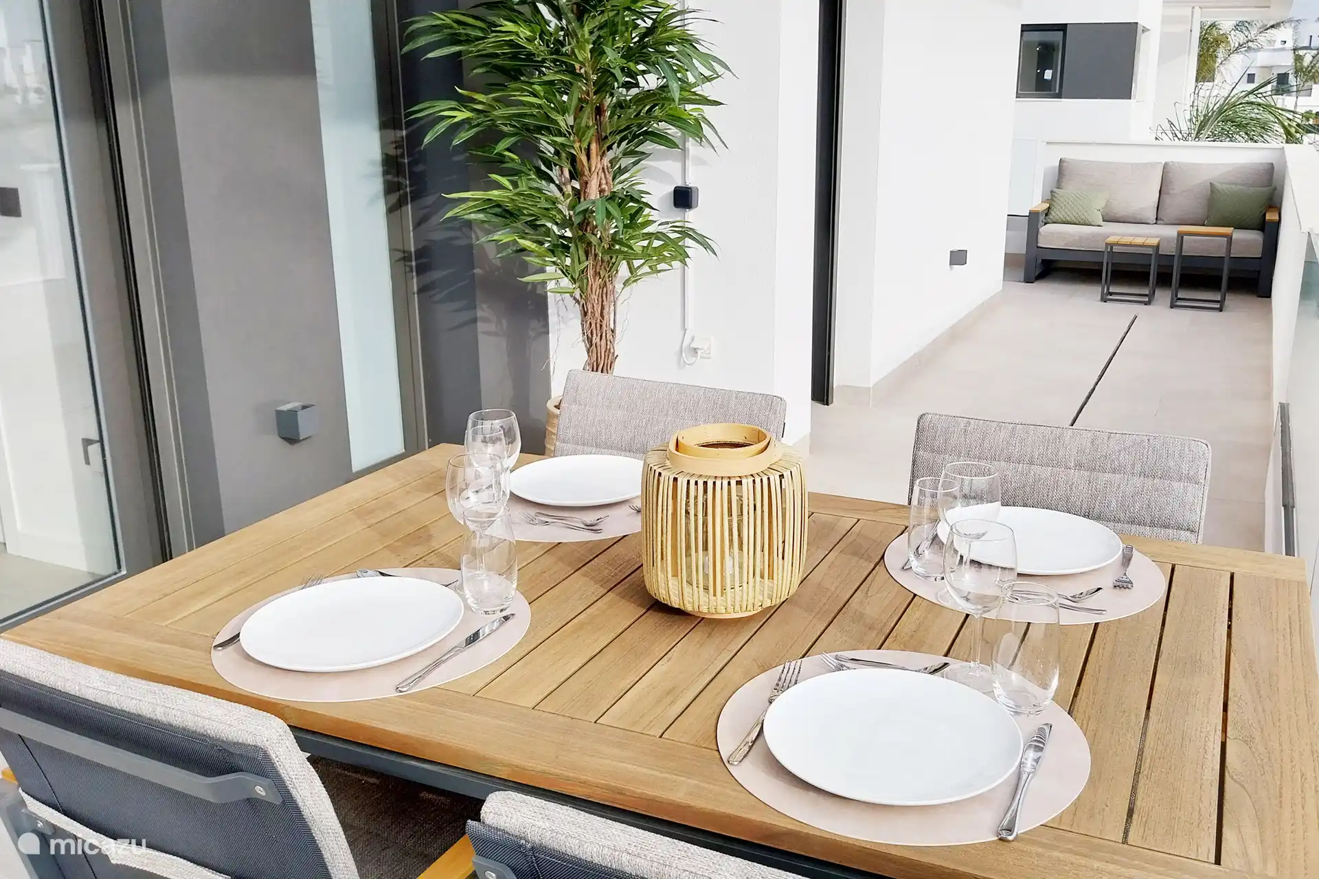 Die Terrasse setzt sich hinter der Ecke der Wohnung fort. Ein Lounge-Sofa blickt auf den wunderschönen Sonnenuntergang und verbindet beide Seiten der geräumigen Terrasse.