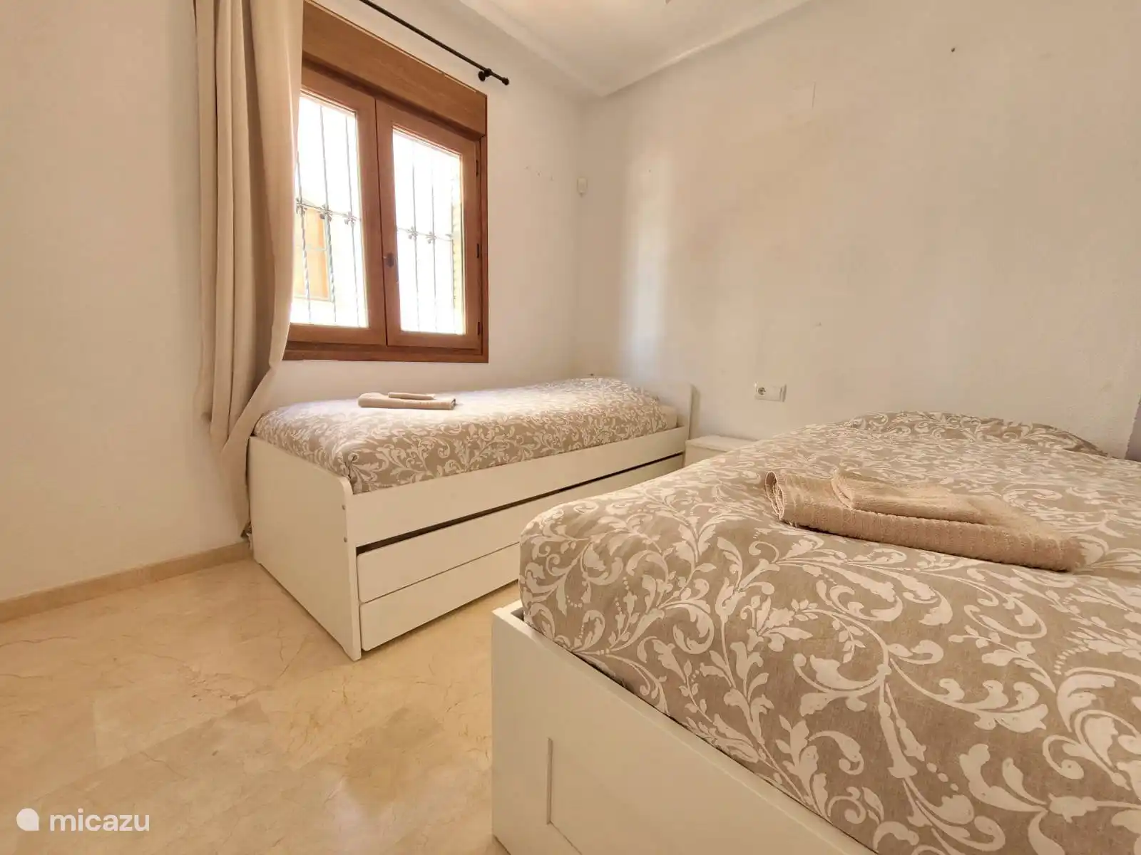 Chambre avec deux lits simples et un look frais et léger. Idéal pour les enfants ou les personnes supplémentaires. Equipé de volets pour une nuit de sommeil sombre et paisible.