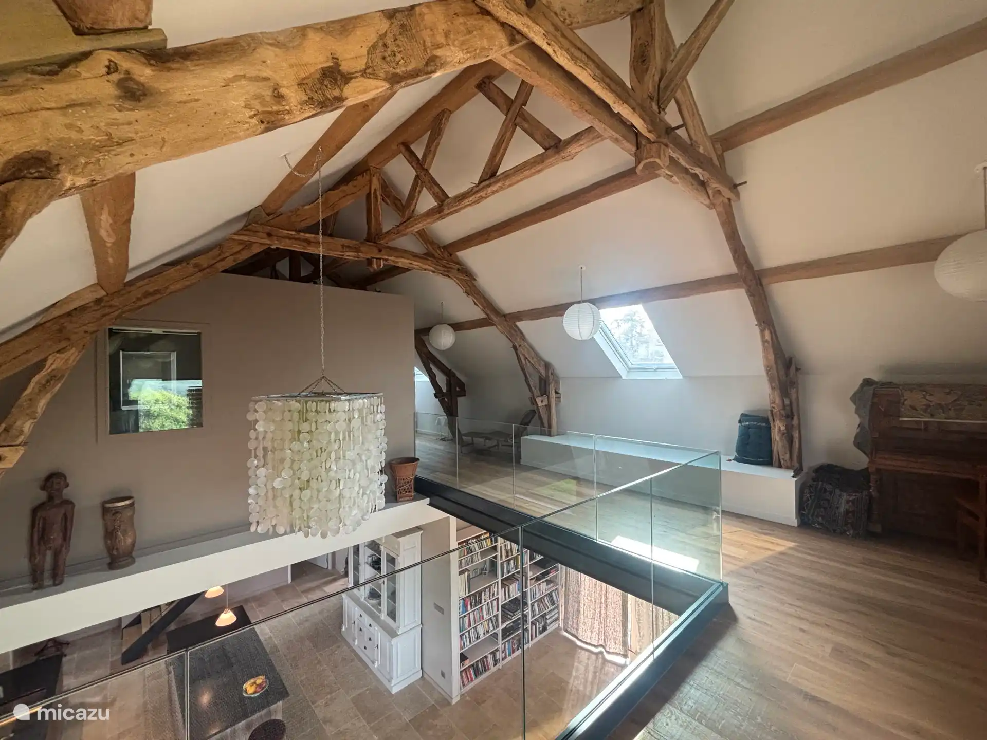 Zwischengeschoss im Obergeschoss mit Blick durch das Loft auf die Küche und das Bücherregal im Erdgeschoss