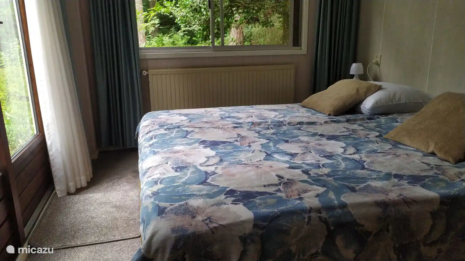 Slaapkamer met openslaande tuindeuren naar het terras