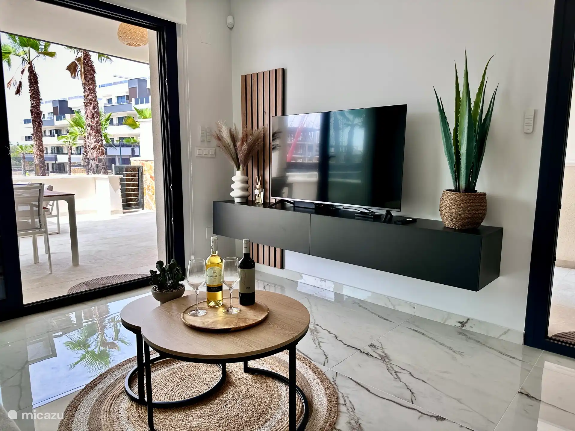 Gezellige zithoek met smart-tv en toegang tot het terras. Geniet van een glas wijn en ontspannen avonden in een moderne setting.