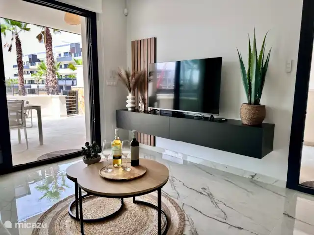 Casa Rosa en España, Costa Blanca, Orihuela Costa - apartamento Acogedora sala de estar con smart TV y acceso a la terraza. Disfrute de una copa de vino y noches relajantes en un ambiente moderno.