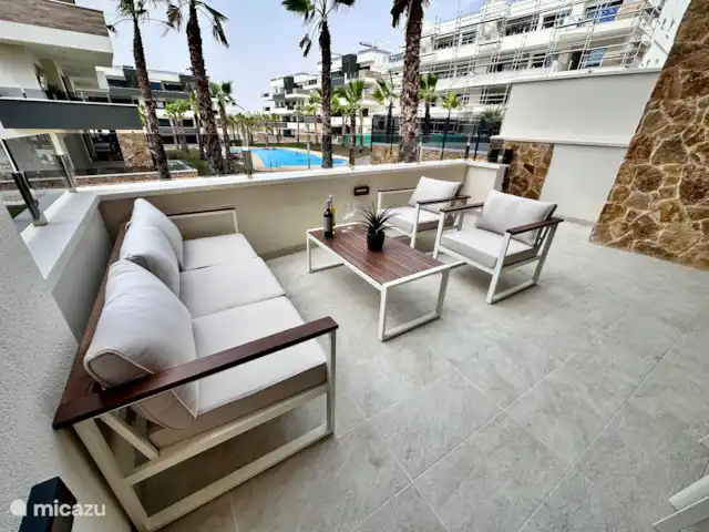 Casa Rosa en España, Costa Blanca, Orihuela Costa - apartamento Amplia terraza con cómodos salones y vistas a la piscina. Disfrute de una bebida al sol o de una velada acogedora con amigos y familiares.