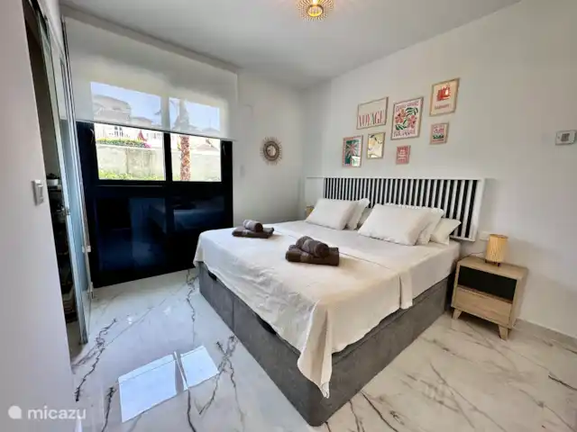 Casa Rosa en España, Costa Blanca, Orihuela Costa - apartamento Cómodo dormitorio principal con cama king-size, decoración elegante y mucha luz. Perfecto para una noche de sueño reparador.