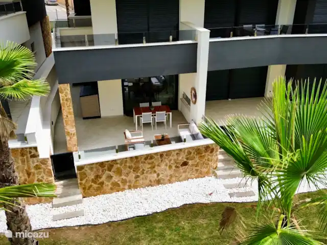 Casa Rosa en España, Costa Blanca, Orihuela Costa - apartamento Amplia terraza con cómodo salón y mesa de comedor, ideal para disfrutar del sol español y de las tardes en familia o con amigos.
