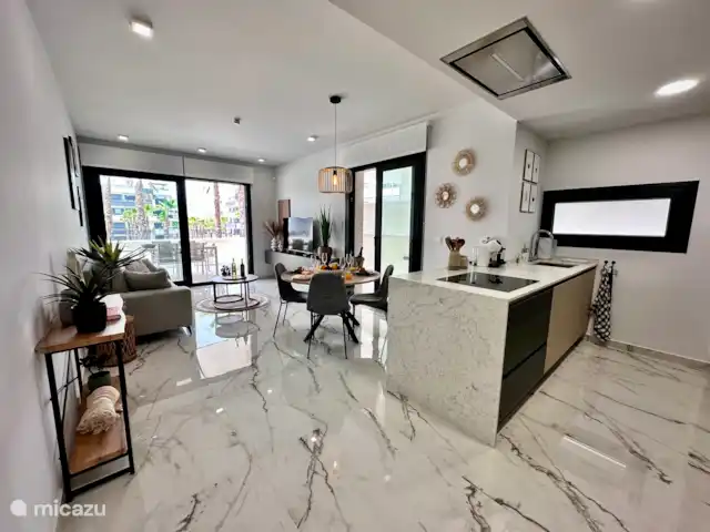 Casa Rosa en España, Costa Blanca, Orihuela Costa - apartamento Moderno salón diáfano con mucha luz, decoración elegante y acceso directo a la terraza con vistas a la piscina.