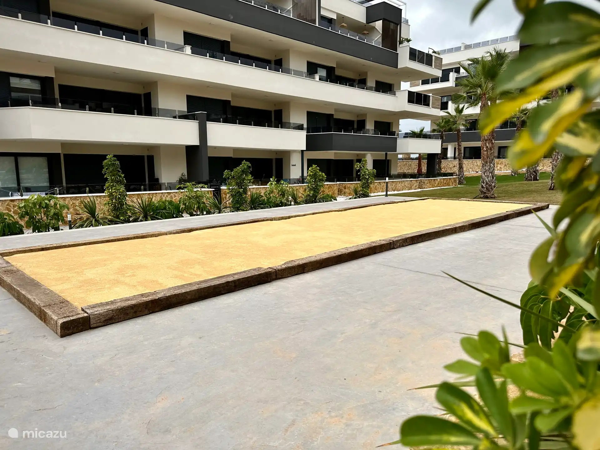 Geniet van een potje jeu-de-boules op de gezamenlijke baan, omringd door palmbomen en een prachtig aangelegde tuin.