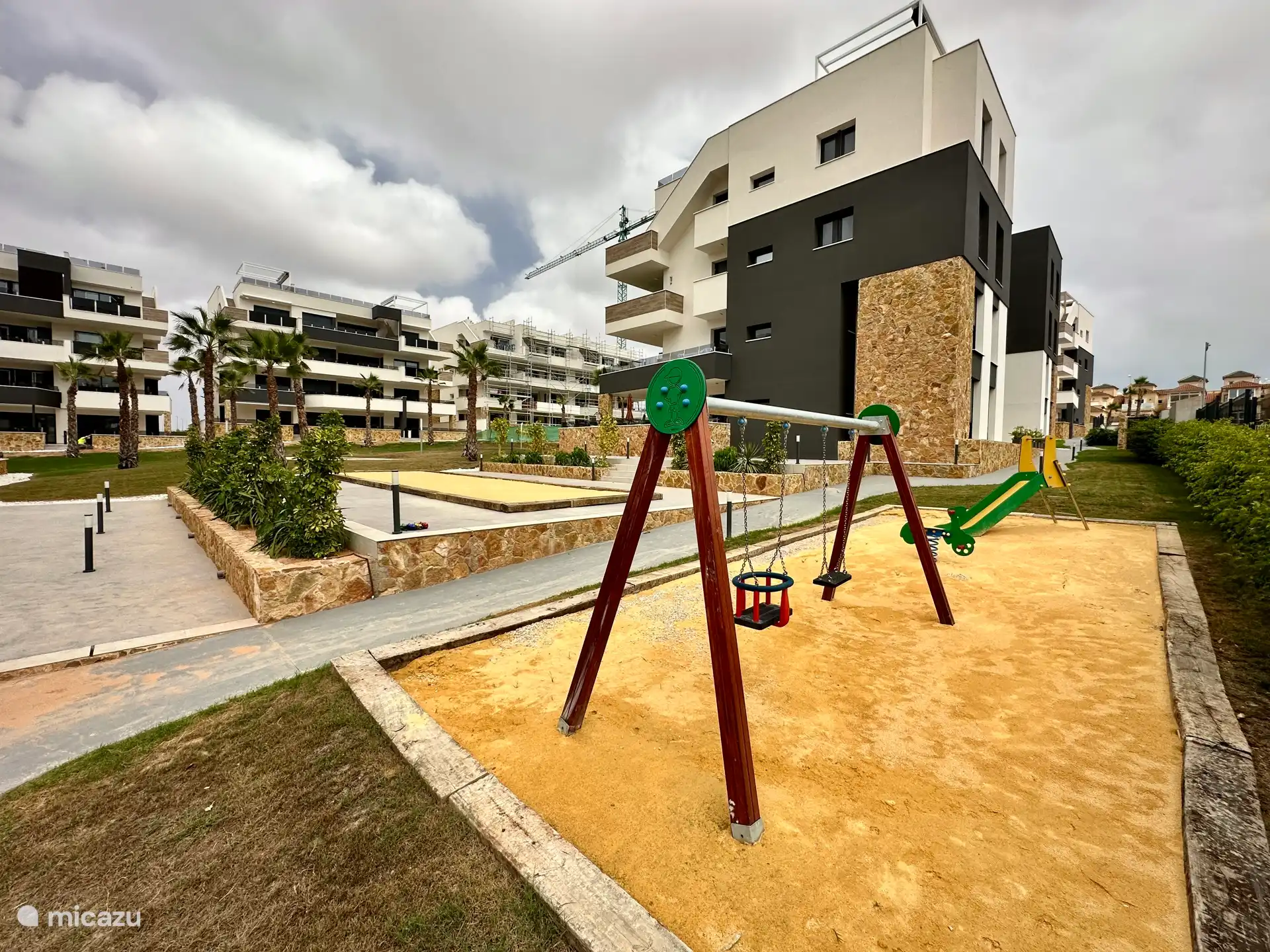 Speeltuin in de gemeenschappelijke tuin, ideaal voor kinderen om veilig te spelen.