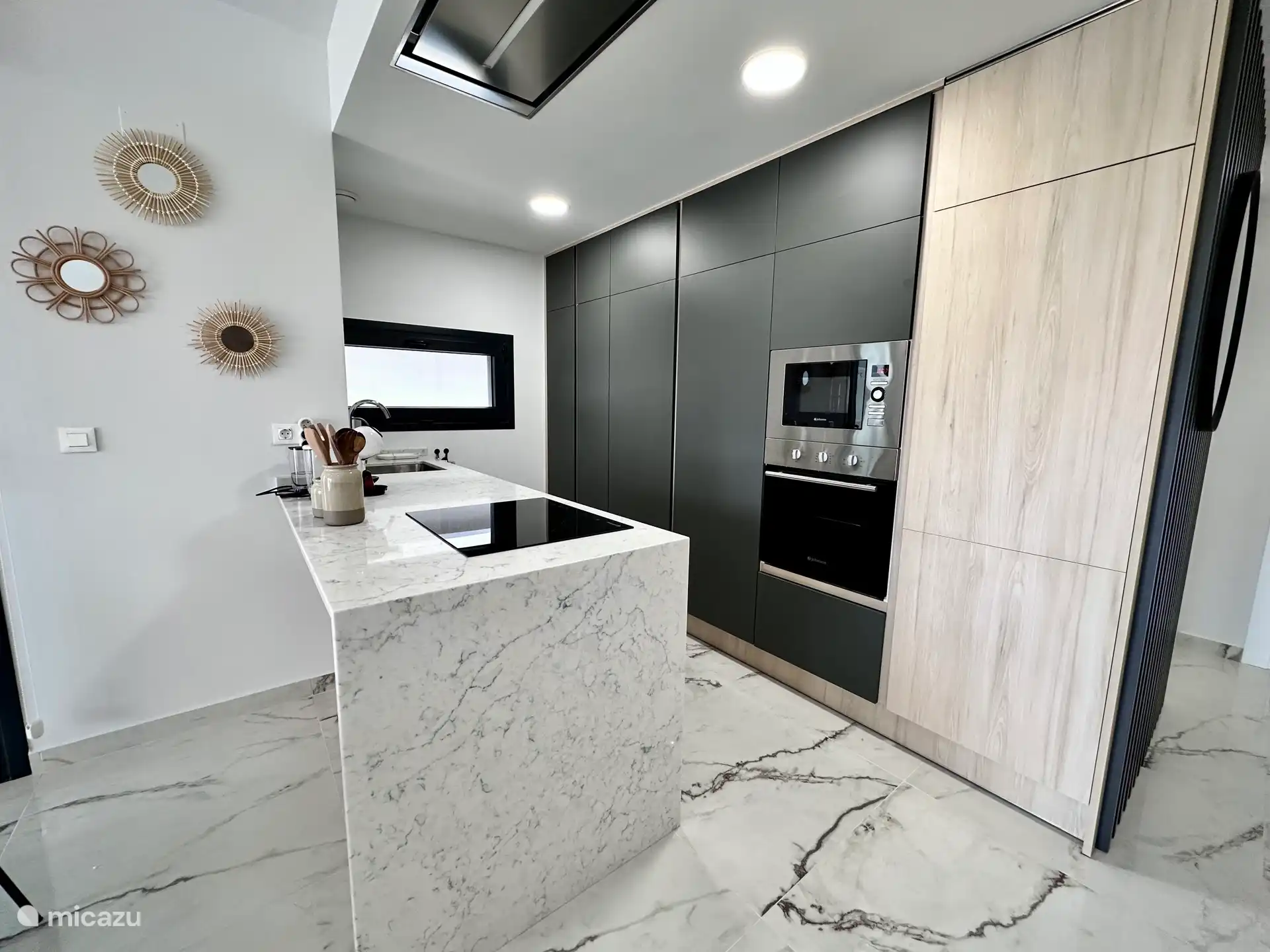 Moderne open keuken met kookeiland, hoogwaardige apparatuur en strak design. Van alle gemakken voorzien voor een zorgeloos verblijf.