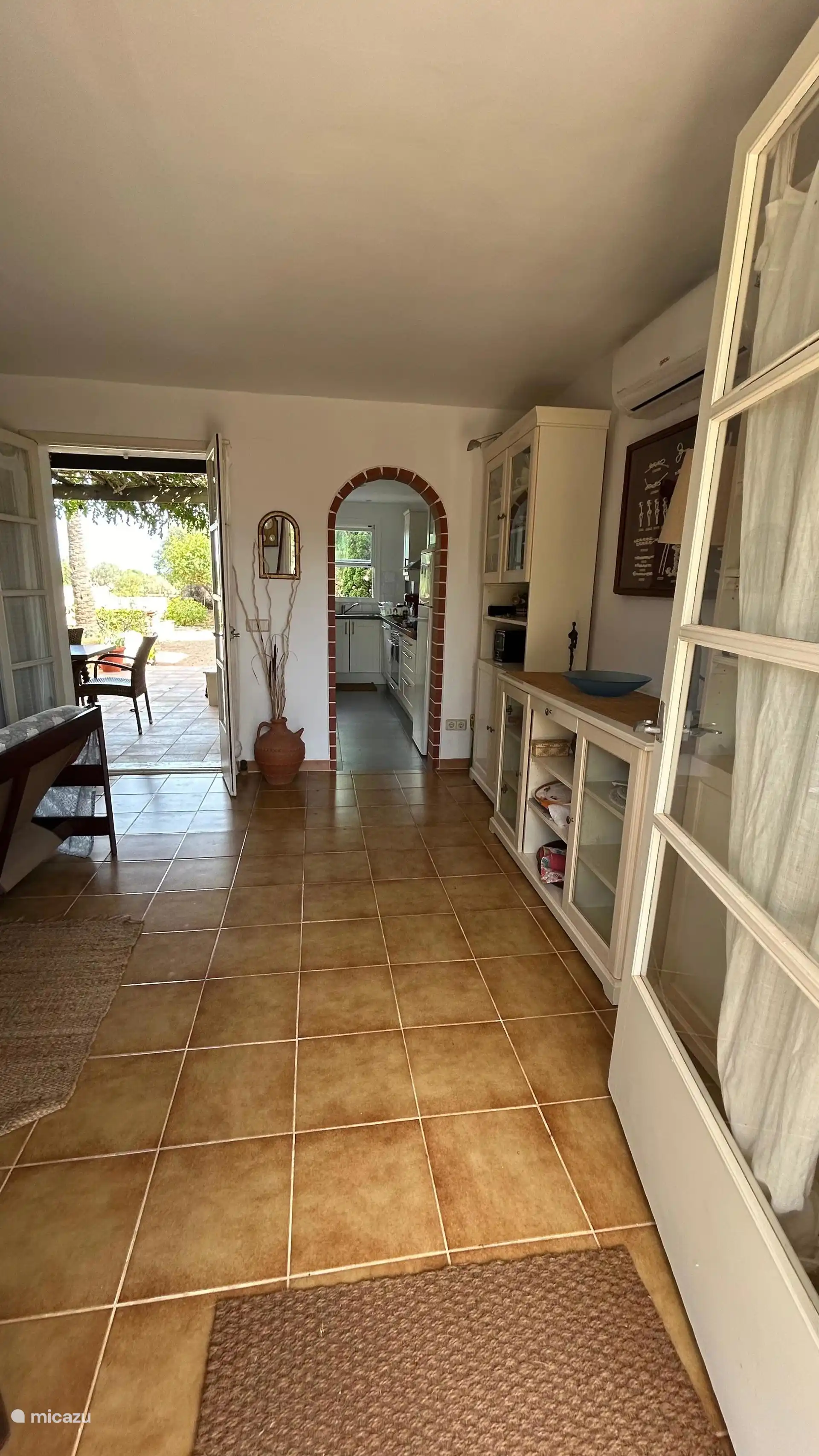 Wohnzimmer mit Tür zur Terrasse und Garten und Küche